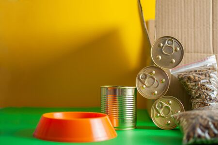 Bowl of a pet with food. Box, cans of canned food. Concept delivery of pet foodの写真素材