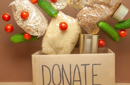 Food donation box. Hand in glove receiving food assistance. Safe food deliveryの写真素材