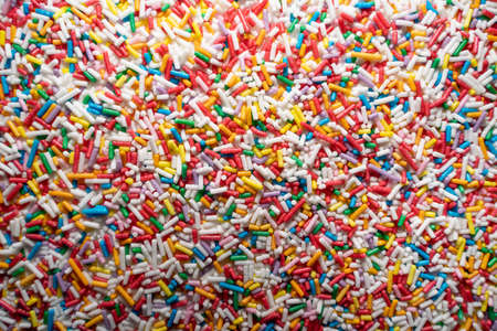 Lots of long multicolored sprinkles candys as a decoration background