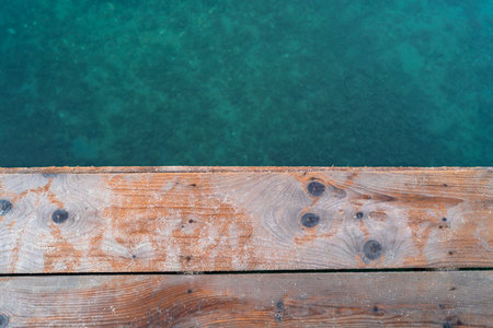 Wooden jetty boards in front of turquoise colored sea waterの写真素材