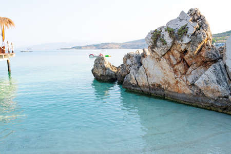 Big rock in the beach with white sand and turquoise sea waterの写真素材