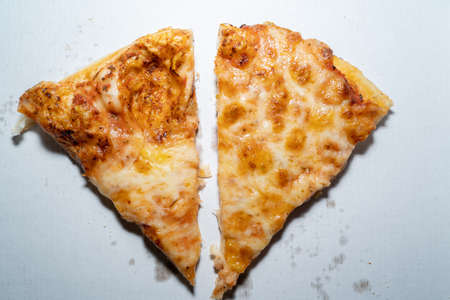 Two pieces of delicious margherita pizza with tomato sauce and cheese on a white pizza box