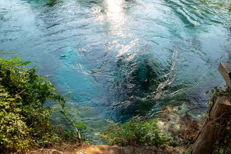 Turquoise colored karst spring in the mountains pushes clear cold water upwardsの写真素材