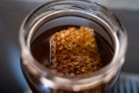 Fresh organic honey with beehive in a jarの写真素材