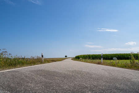 Low angle view of a road in the landscape with nice blue sky in summerの写真素材