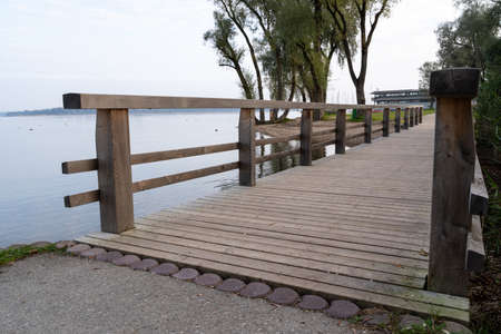 Wooden bridge for pedestrians on a lake in an autumn morningの写真素材