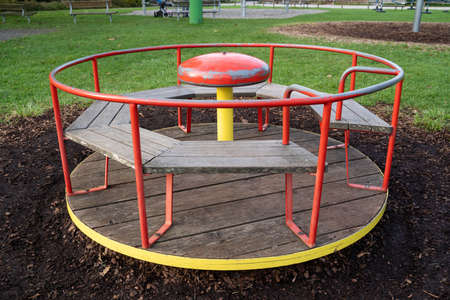 Round red and yellow carousel for children in the playground