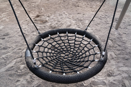 Round nest swing for kids with sand on the floorの写真素材