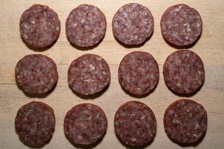 Sliced ââââgarlic sausage slices on a wooden cutting boardの写真素材
