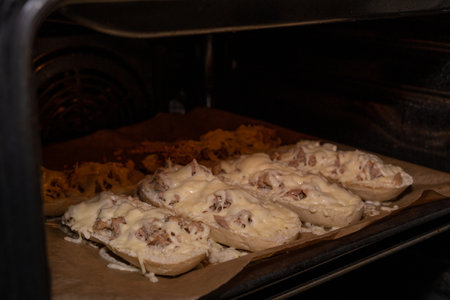 Halved baguette rolls with tuna and melted cheese in the ovenの写真素材