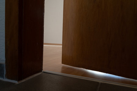 Old open wooden door in room of an empty apartment