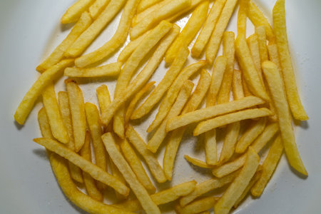 Fried and salted fries on a white plateの写真素材