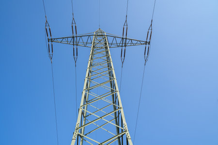 Metal pylon with electric wires in the blue skyの写真素材