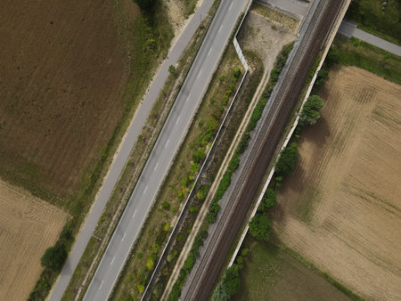View from above of an asphalt road and railway tracks