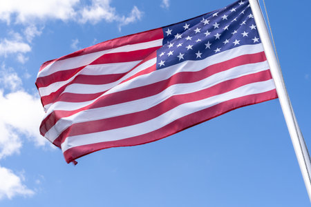American flag waves in blue skyの写真素材