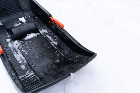 Black children's plastic sled in the snow