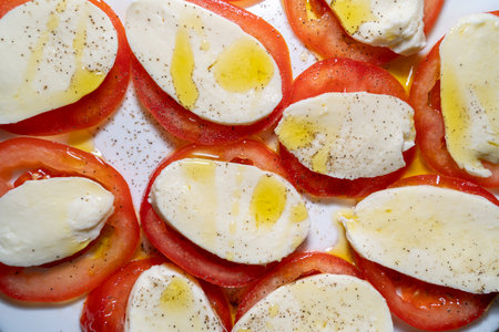 Close up of tomato mozzarella with olive oil on a plateの写真素材