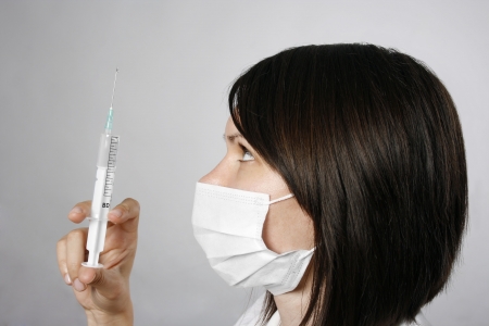 Beautiful nurse in mask with syringe の写真素材