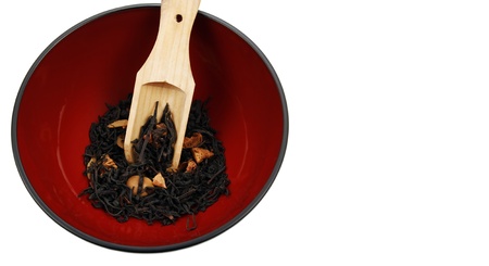 Tea in wooden spoon and red bowl isolated on white backgroundの写真素材