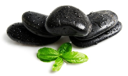 Spa black stones and green leafsの写真素材