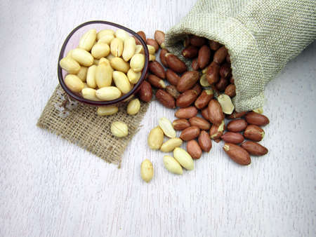 Peanuts in burlap bag on wooden table