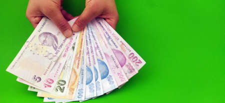Turkish banknote  held by two hands (200-100 -50-20-10 Turkish Lira) on green background