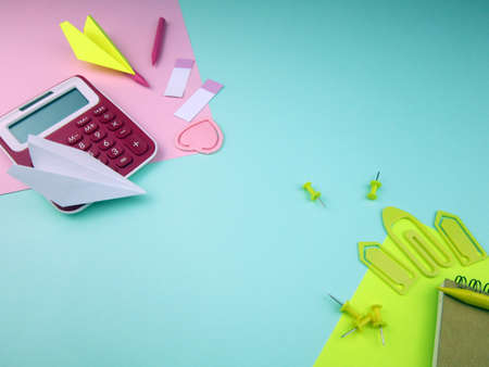 Creative trendy minimalist school or office workspace with yellow and pink materials on a cyan...
