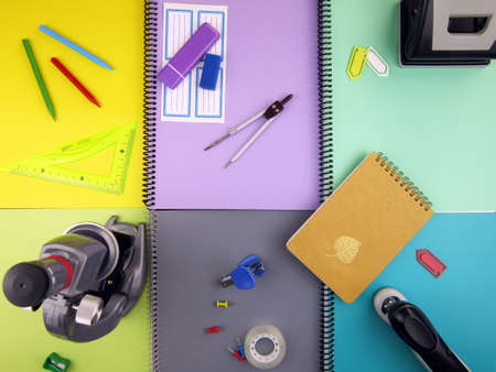 microscope and school supplies on colorful background