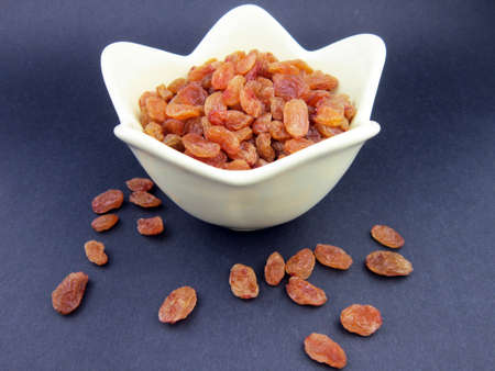 A bowl of yellow golden raisinsの写真素材