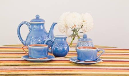 tea or coffee set on table with colorful line fabric in gray wall roomの写真素材