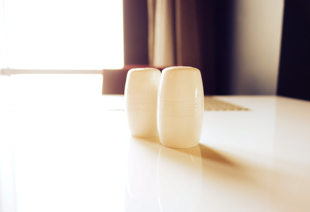 a photo of salt and pepper bottles on table in morningの写真素材