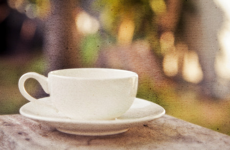 a white cup of coffee in garden backgroundの写真素材