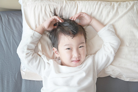 a portrait photo of close up child face on the bedの写真素材