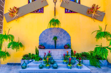 A decorated fountain with bottles of plants and flowersのeditorial素材