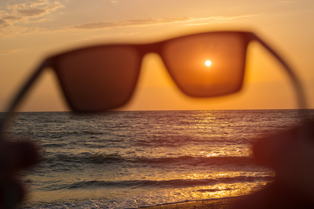 Concept image of seaside sunset with beach scene in sunglasses.の写真素材