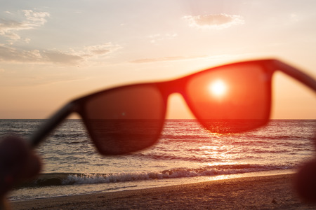 Image of blurred sunglasses on a seaside background. Vacation image for travel themes.の写真素材