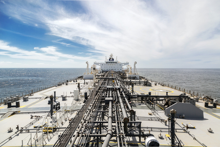 Deck of a new oil tanker in the sea under sky. View from the bow to stern.の写真素材