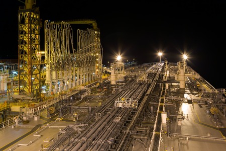 Oil transfer terminal with moored to the berth tanker at night.の写真素材