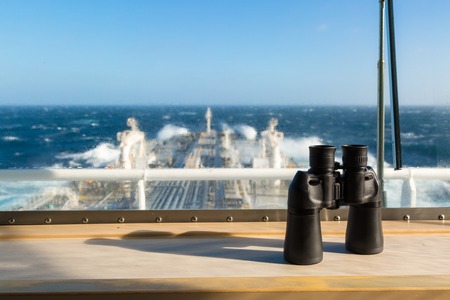 Binocular on the windowsill of navigation bridge against blurred background.