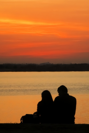 Silhouette of Lovers Against Sunsetの写真素材