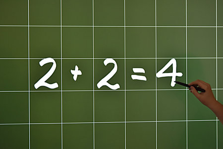 a marker in hand on a computer panel in a school classroom, the inscription two plus two equals four on a checkered backgroundの写真素材