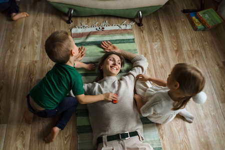 Mom and children. Boy and girl. Lie together. Happy family.の写真素材