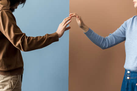 Two hands touch each other with their fingertips on different backgrounds.の写真素材