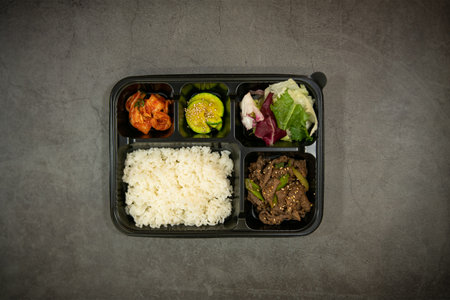 Lunch box with rice, vegetables and meat on gray background.の写真素材