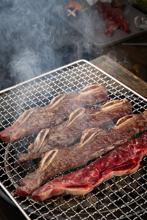 Beef steak being grilled on a barbecue grill in a restaurant.の写真素材