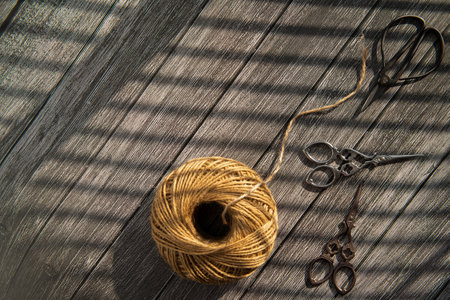 Scissors and thread on a wooden background. View from above.の写真素材