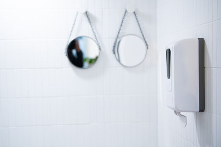 Blurred background of modern bathroom with white tiled walls and mirrorの写真素材