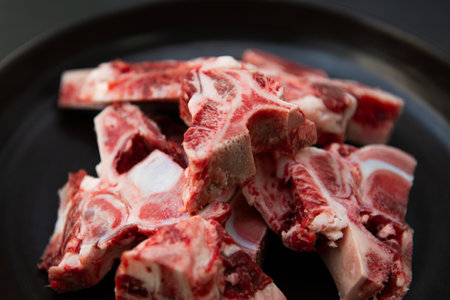 Raw lamb ribs on black plate, ready for cooking. Selective focus.の写真素材
