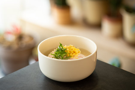 Rice soup with chicken in a white bowl on the table.の写真素材