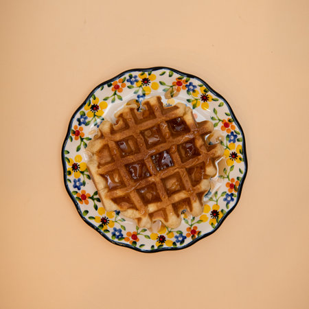Belgian waffles on a plate on a yellow background, top viewの写真素材